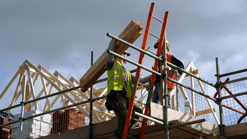 Australian construction worker lifting timber
